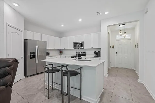 a kitchen with stainless steel appliances granite countertop a refrigerator and a stove top oven