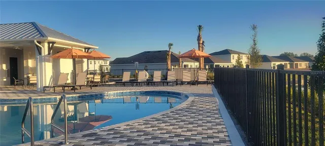 a view of a house with pool and chairs