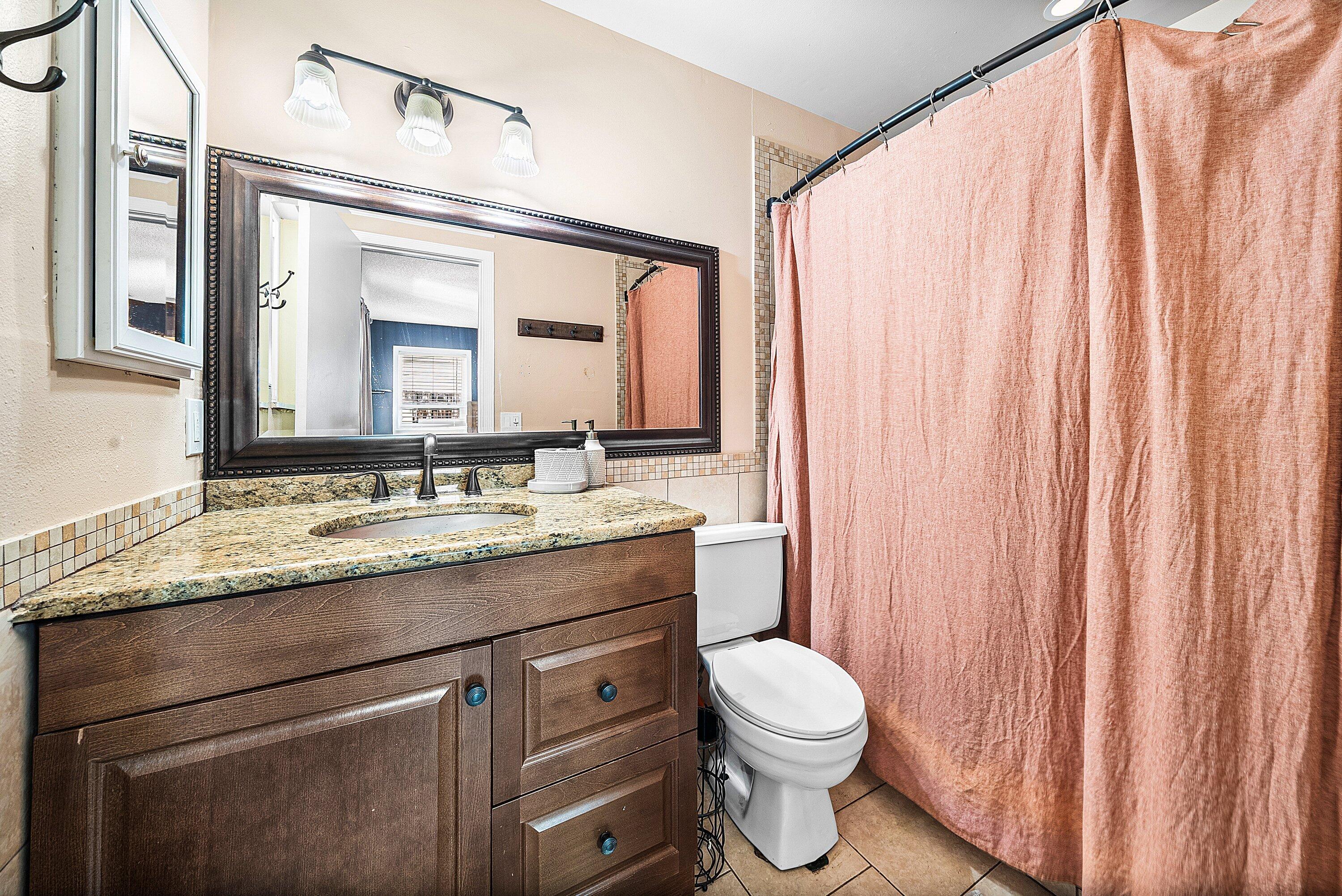 4500 Southeast Salvatori Road Stuart, FL 34997 - Photo 14 of 25 a bathroom with a granite countertop sink toilet and mirror