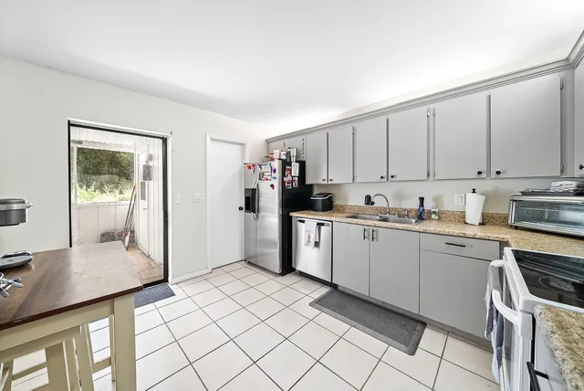 a kitchen with white cabinets a sink and white appliances