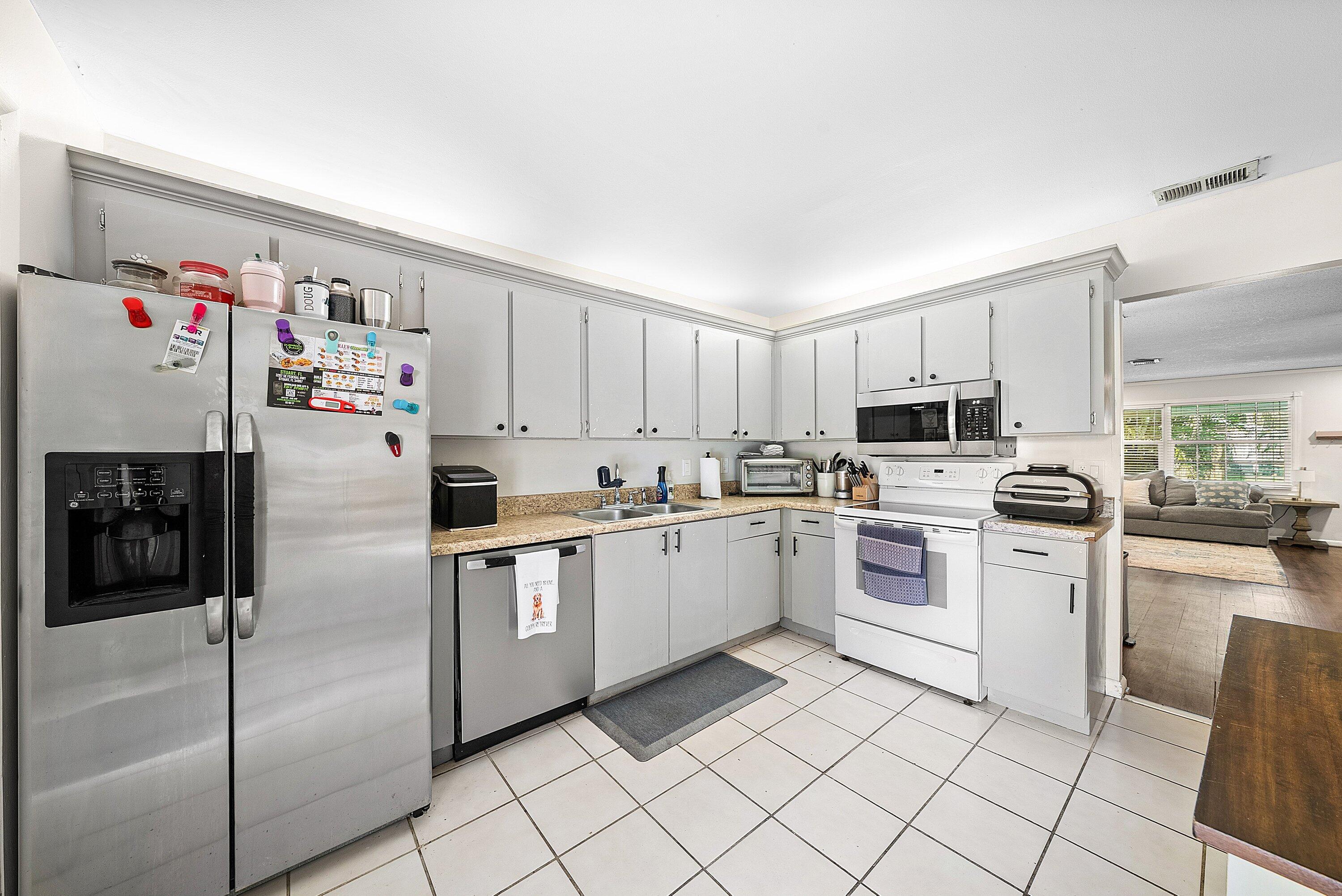 4500 Southeast Salvatori Road Stuart, FL 34997 - Photo 17 of 25 a kitchen with white cabinets stainless steel appliances and white appliances