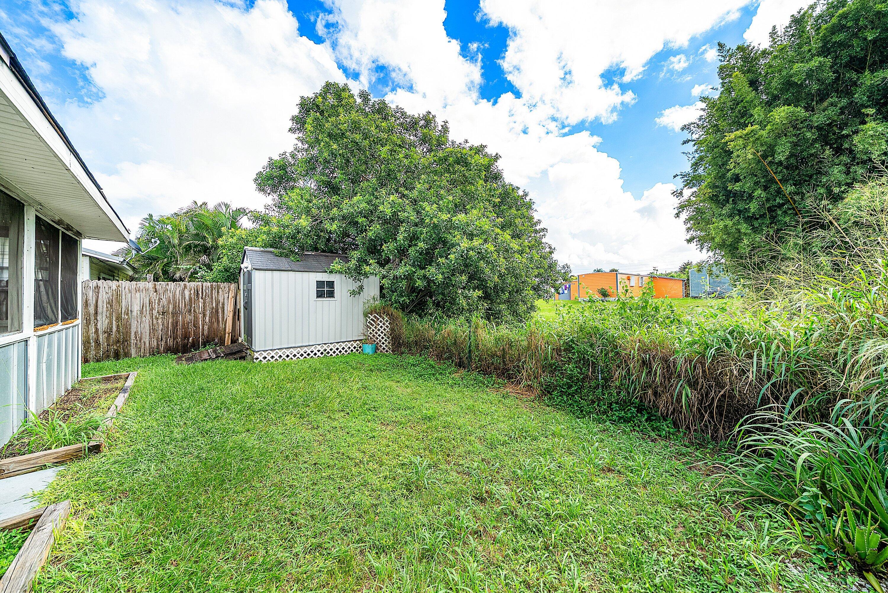 4500 Southeast Salvatori Road Stuart, FL 34997 - Photo 22 of 25 a view of a backyard with large trees and wooden fence