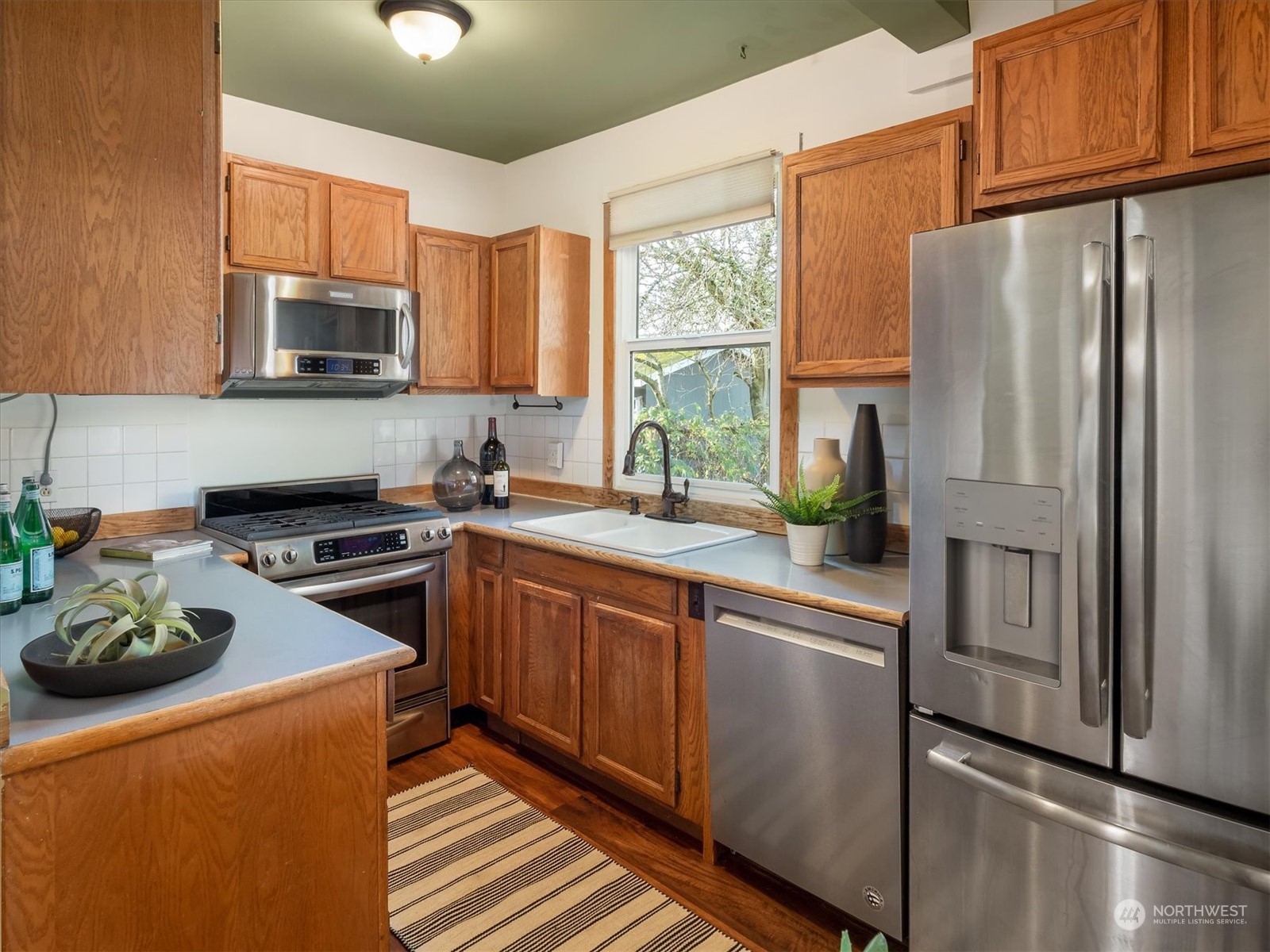 610 Maple Street Edmonds, WA 98020 - Photo 13 of 36 a kitchen with stainless steel appliances granite countertop a refrigerator sink and stove