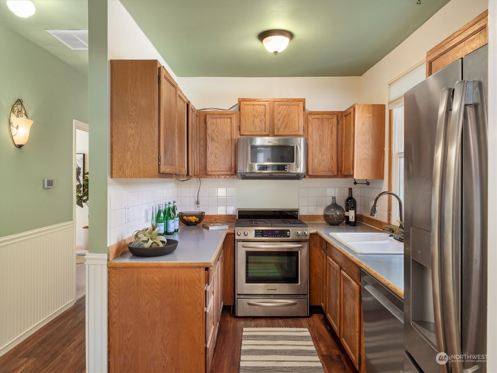 610 Maple Street Edmonds, WA 98020 - Photo 14 of 36 a kitchen with stainless steel appliances granite countertop a stove a sink a refrigerator and a microwave