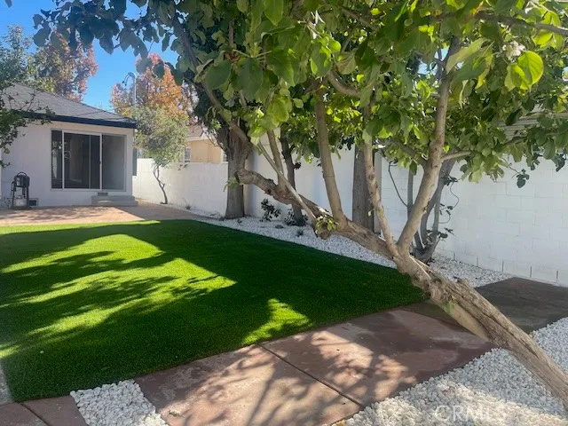 a view of a house with backyard and tree s