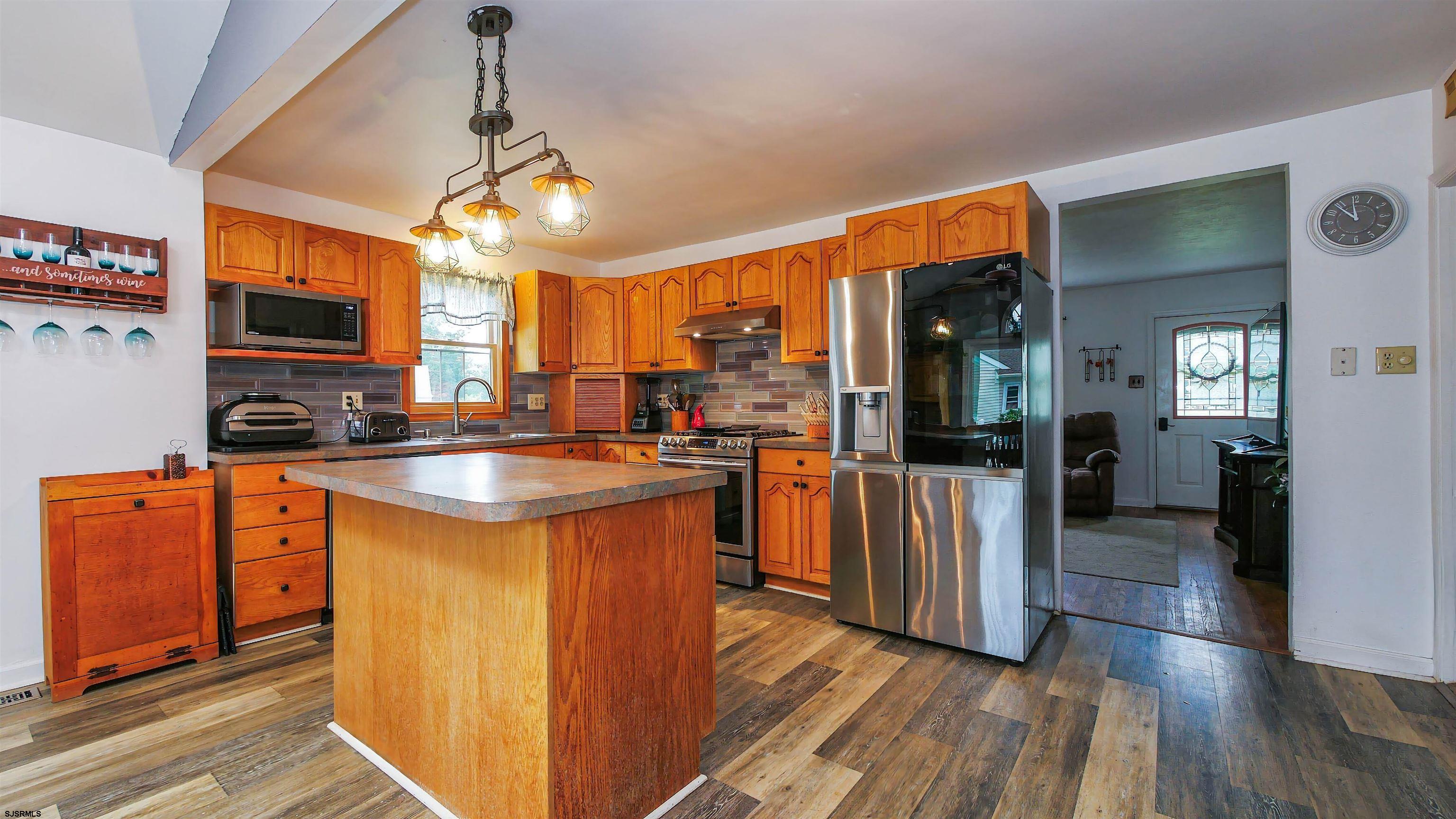 2 Rose Lane Somers Point, NJ 08244 - Photo 8 of 43 a kitchen with stainless steel appliances granite countertop a refrigerator a sink dishwasher a stove and white countertops with wooden floor