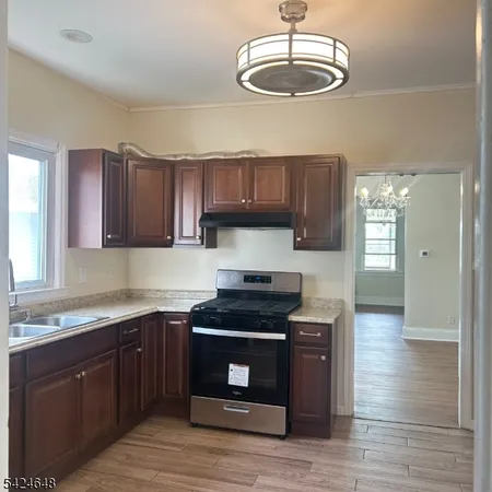 a kitchen with granite countertop stainless steel appliances a stove a sink and cabinets
