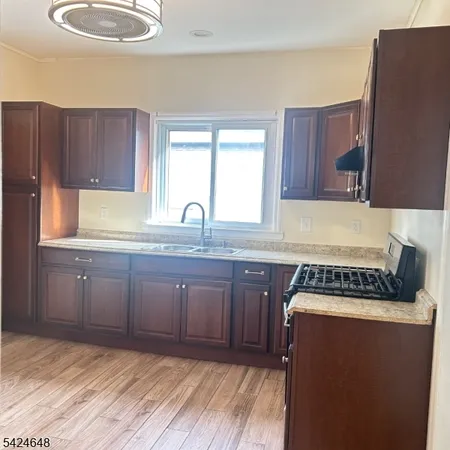 a kitchen with granite countertop a sink a stove and cabinets