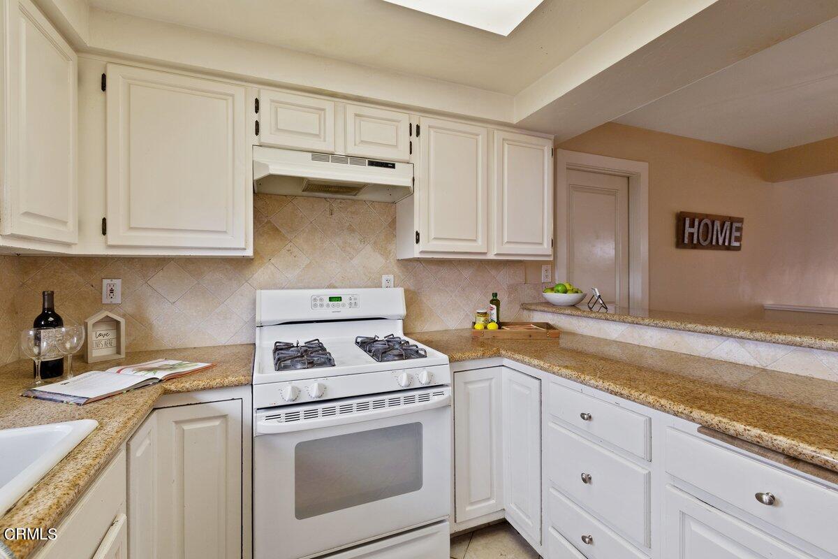 5024 West Wooley Road Oxnard, CA 93035 - Photo 10 of 33 a kitchen with granite countertop white cabinets and white appliances