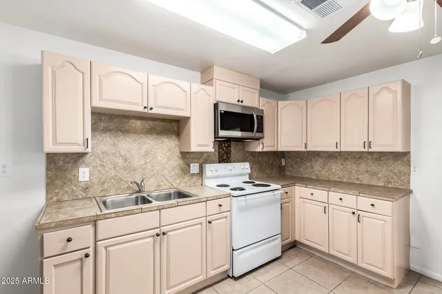 a kitchen with white cabinets stainless steel appliances and sink