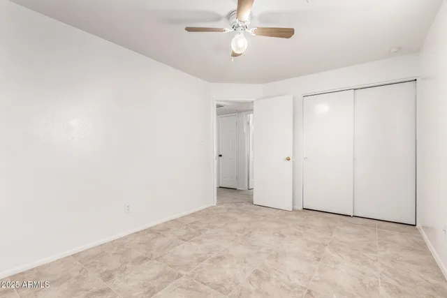 an empty room with chandelier fan
