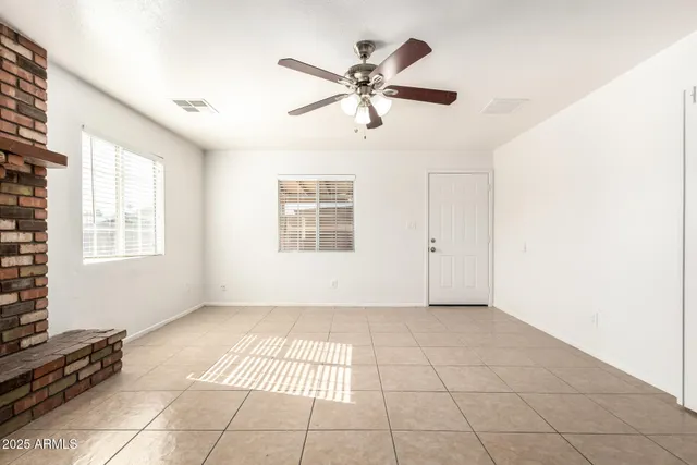 a view of an empty room with a fireplace and a window