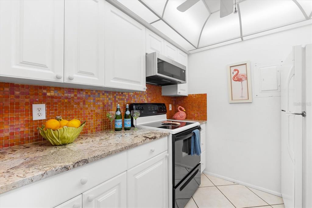 5641 Midnight Pass Road, Unit 902 Sarasota, FL 34242 - Photo 13 of 81 a kitchen with stainless steel appliances granite countertop a sink and a white cabinets