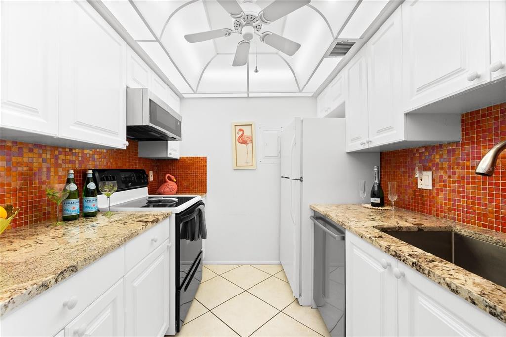 5641 Midnight Pass Road, Unit 902 Sarasota, FL 34242 - Photo 14 of 81 a kitchen with stainless steel appliances granite countertop a sink stove and refrigerator