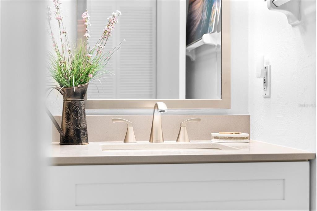 5641 Midnight Pass Road, Unit 902 Sarasota, FL 34242 - Photo 24 of 81 a bathroom with a sink a mirror and a potted plant