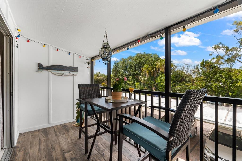 5641 Midnight Pass Road, Unit 902 Sarasota, FL 34242 - Photo 59 of 81 a view of a porch with furniture and wooden floor