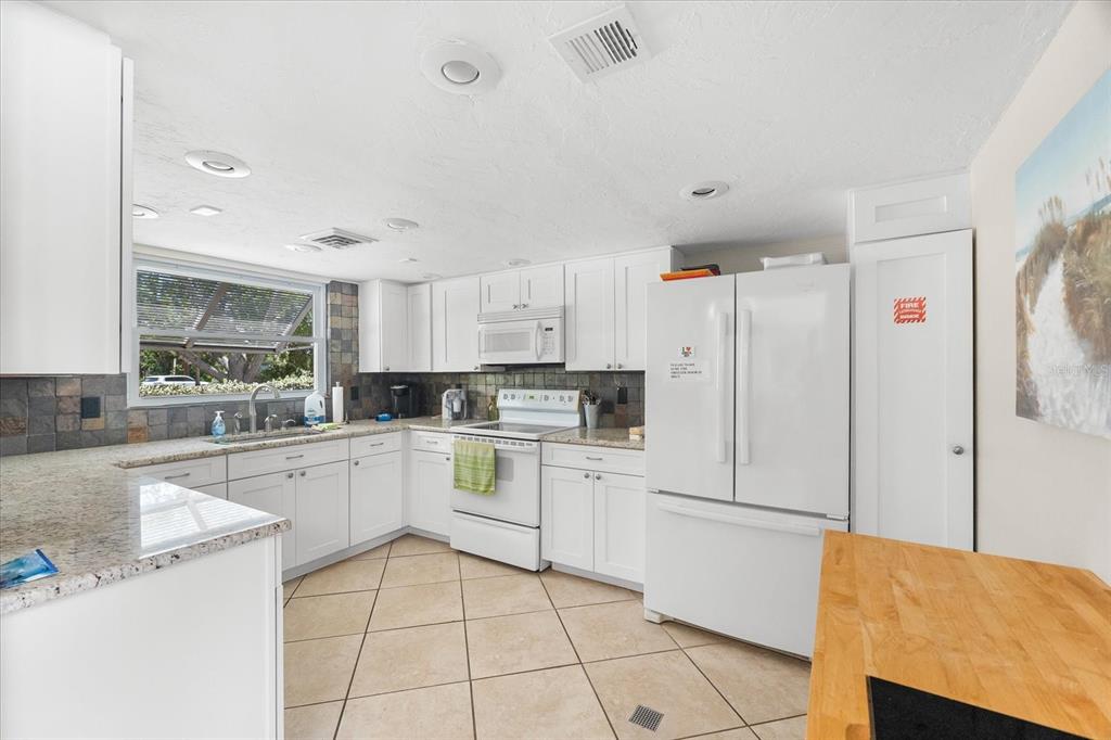 5641 Midnight Pass Road, Unit 902 Sarasota, FL 34242 - Photo 65 of 81 a kitchen with white cabinets and white appliances