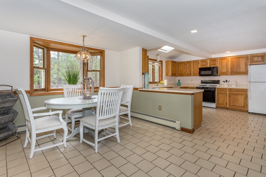 49 Angela Street Canton, MA 02021 - Photo 4 of 25 a dining area with stainless steel appliances a table and chairs