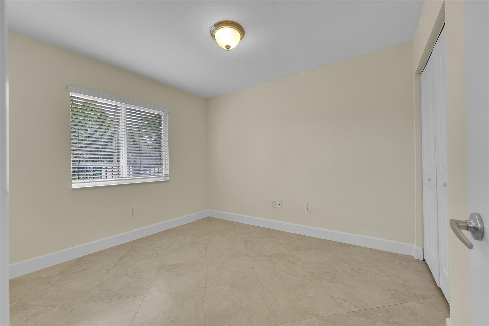 410 Southwest 15th Street, Unit 103 Pompano Beach, FL 33060 - Photo 13 of 16 an empty room with a window