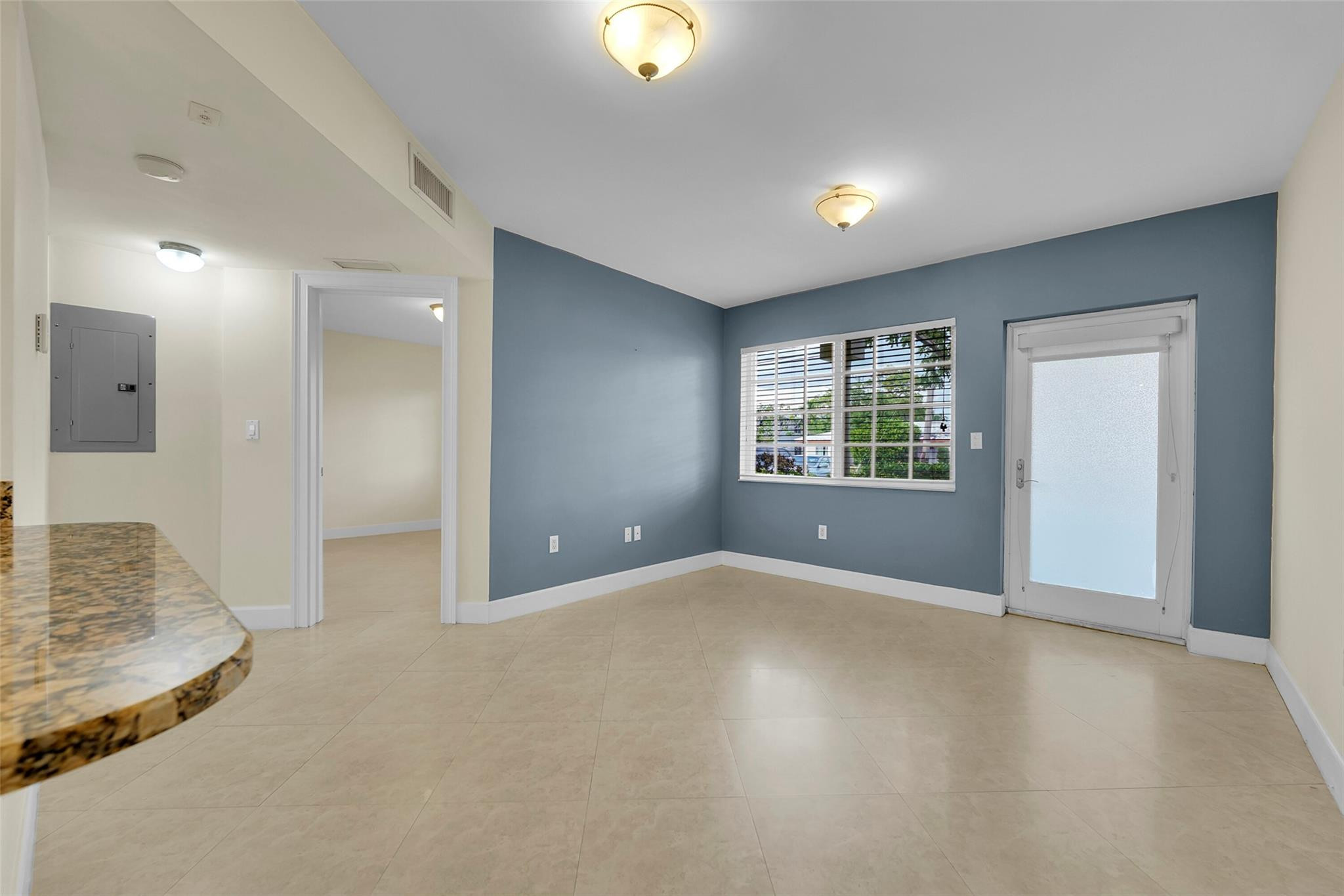 410 Southwest 15th Street, Unit 103 Pompano Beach, FL 33060 - Photo 5 of 16 an empty room with windows and entrance