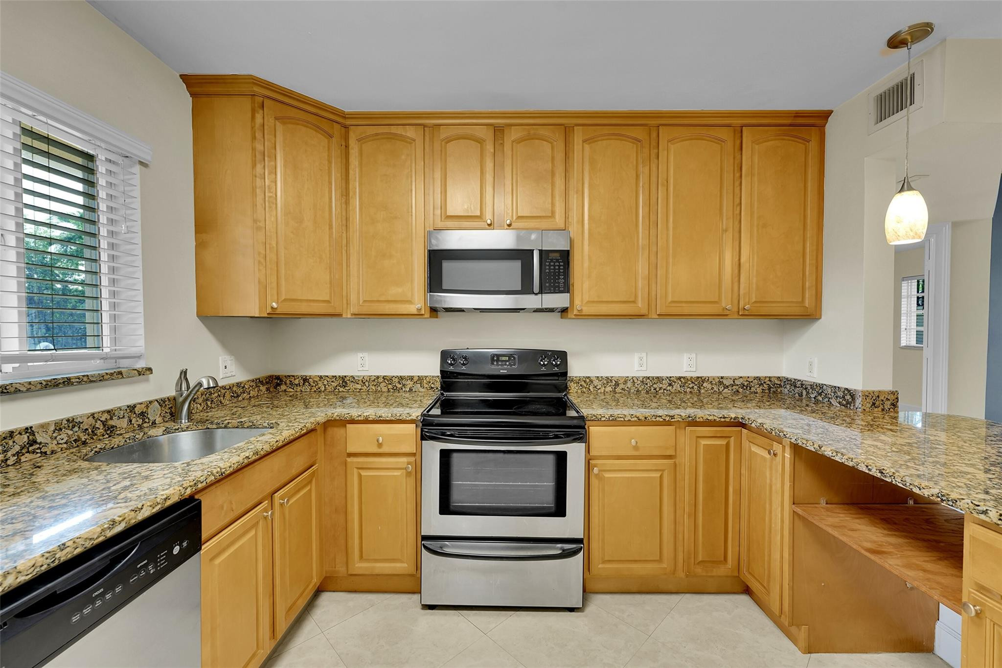 410 Southwest 15th Street, Unit 103 Pompano Beach, FL 33060 - Photo 7 of 16 a kitchen with granite countertop a stove and a sink