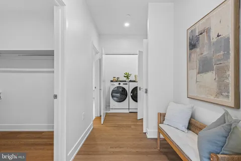 a hallway with a couch and a dining table with wooden floor