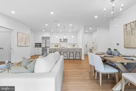 a living room with stainless steel appliances kitchen island granite countertop furniture and a dining table