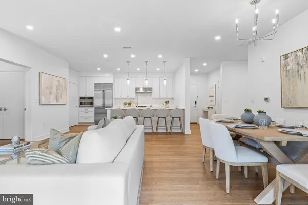 a living room with stainless steel appliances kitchen island granite countertop furniture and a dining table