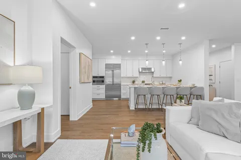 a living room with furniture and a dining table with kitchen view
