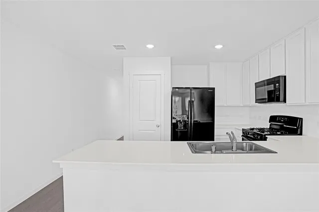 a view of a kitchen with flat screen tv and refrigerator