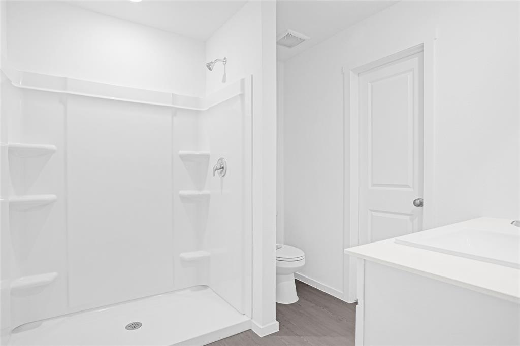 1033 Raintree Road Princeton, TX 75407 - Photo 17 of 25 a bathroom with a shower a toilet and a shower