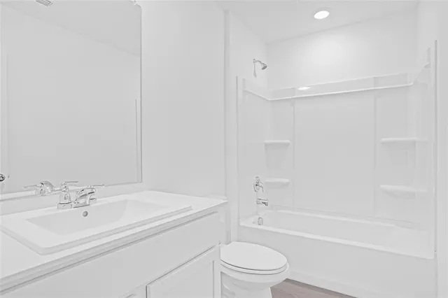 a bathroom with a bathtub shower sink vanity and toilet