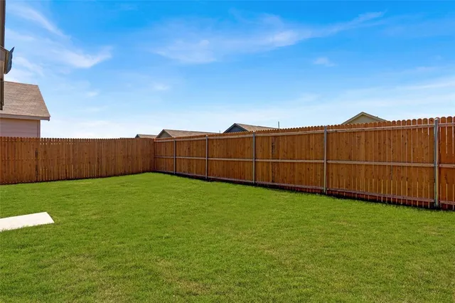 a view of a backyard with wooden fence