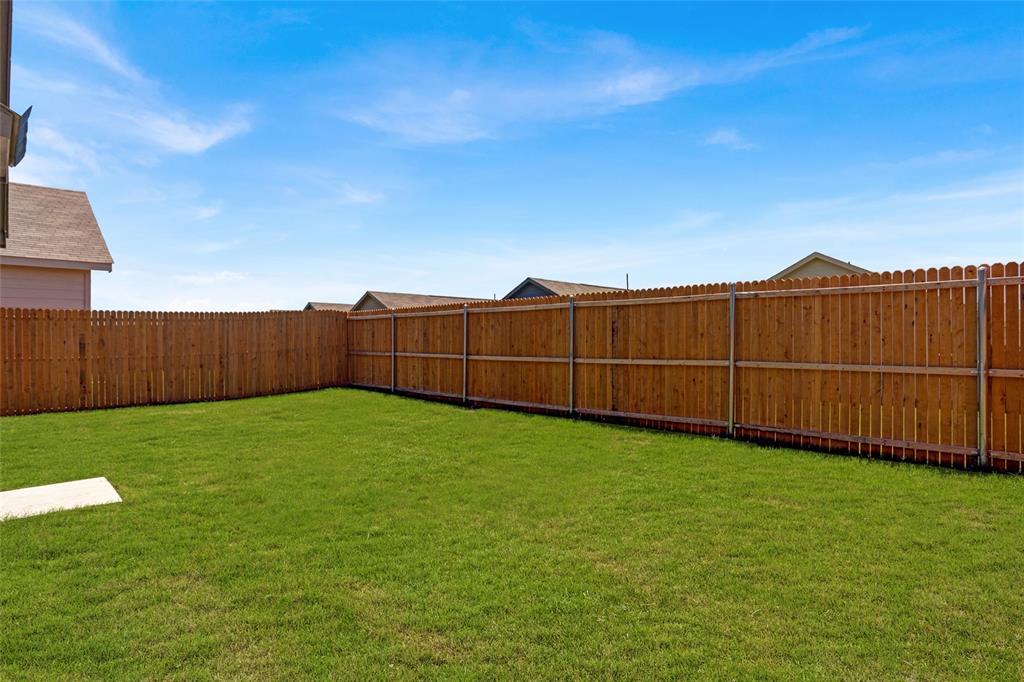 1033 Raintree Road Princeton, TX 75407 - Photo 3 of 25 a view of a backyard with wooden fence