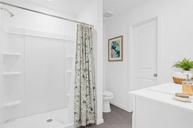 a bathroom with a shower toilet and sink