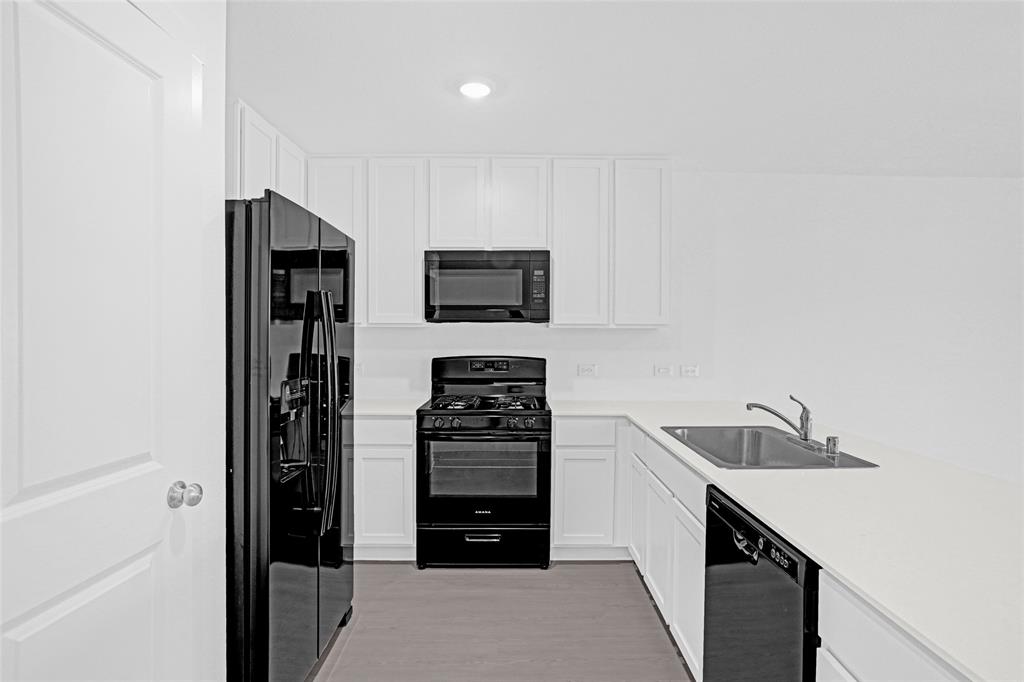 1033 Raintree Road Princeton, TX 75407 - Photo 6 of 25 a kitchen with stainless steel appliances a refrigerator and a stove top oven