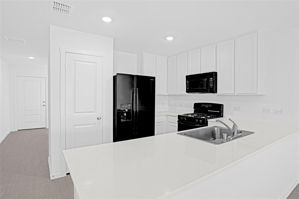 1033 Raintree Road Princeton, TX 75407 - Photo 8 of 26 a bedroom with a bed and a flat tv screen in it