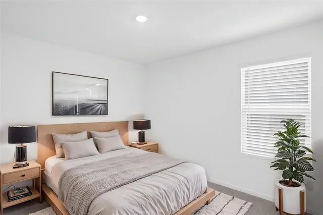 a bedroom with bed and a potted plant