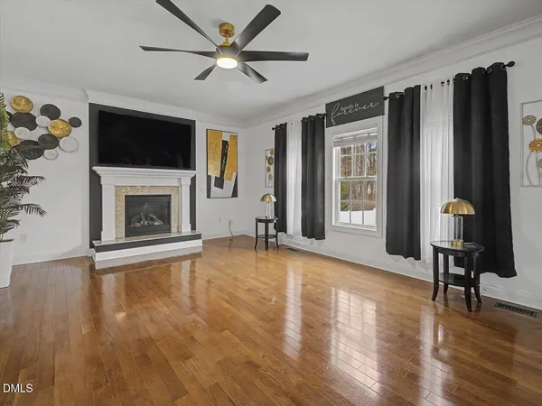 a living room with furniture a flat screen tv and a fireplace