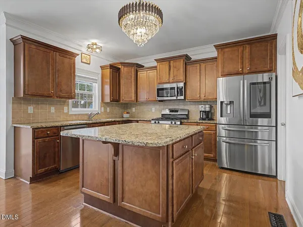 a kitchen with stainless steel appliances granite countertop wooden cabinets a stove a sink and dishwasher