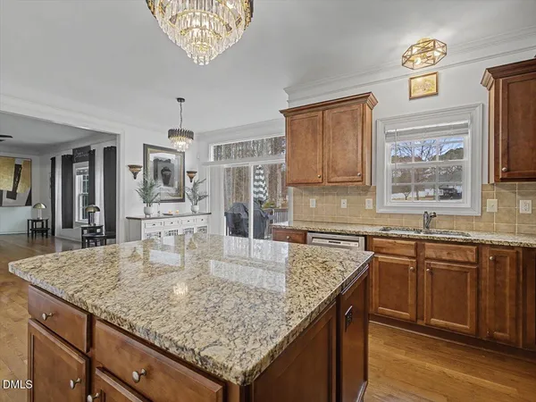 a kitchen with stainless steel appliances granite countertop a sink dishwasher stove and refrigerator with wooden floor