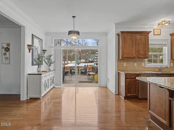 a view of a kitchen with kitchen island a large counter top space a sink stainless steel appliances and cabinets
