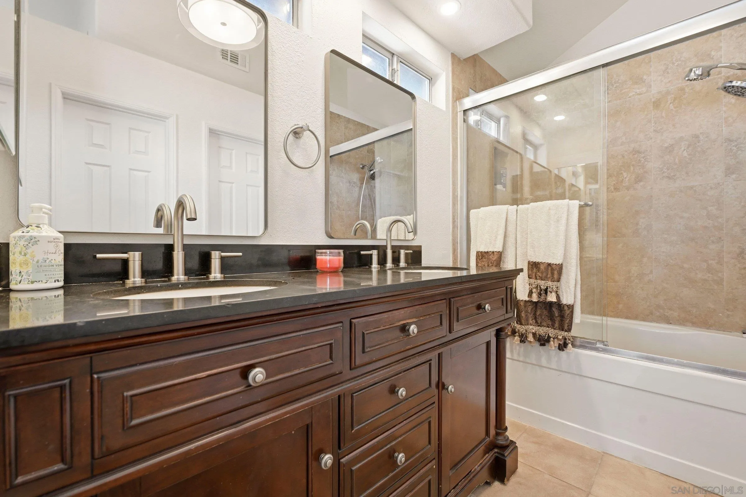 4290 Via Clemente Oceanside, CA 92057 - Photo 26 of 34 a bathroom with a double vanity sink a mirror and a bathtub