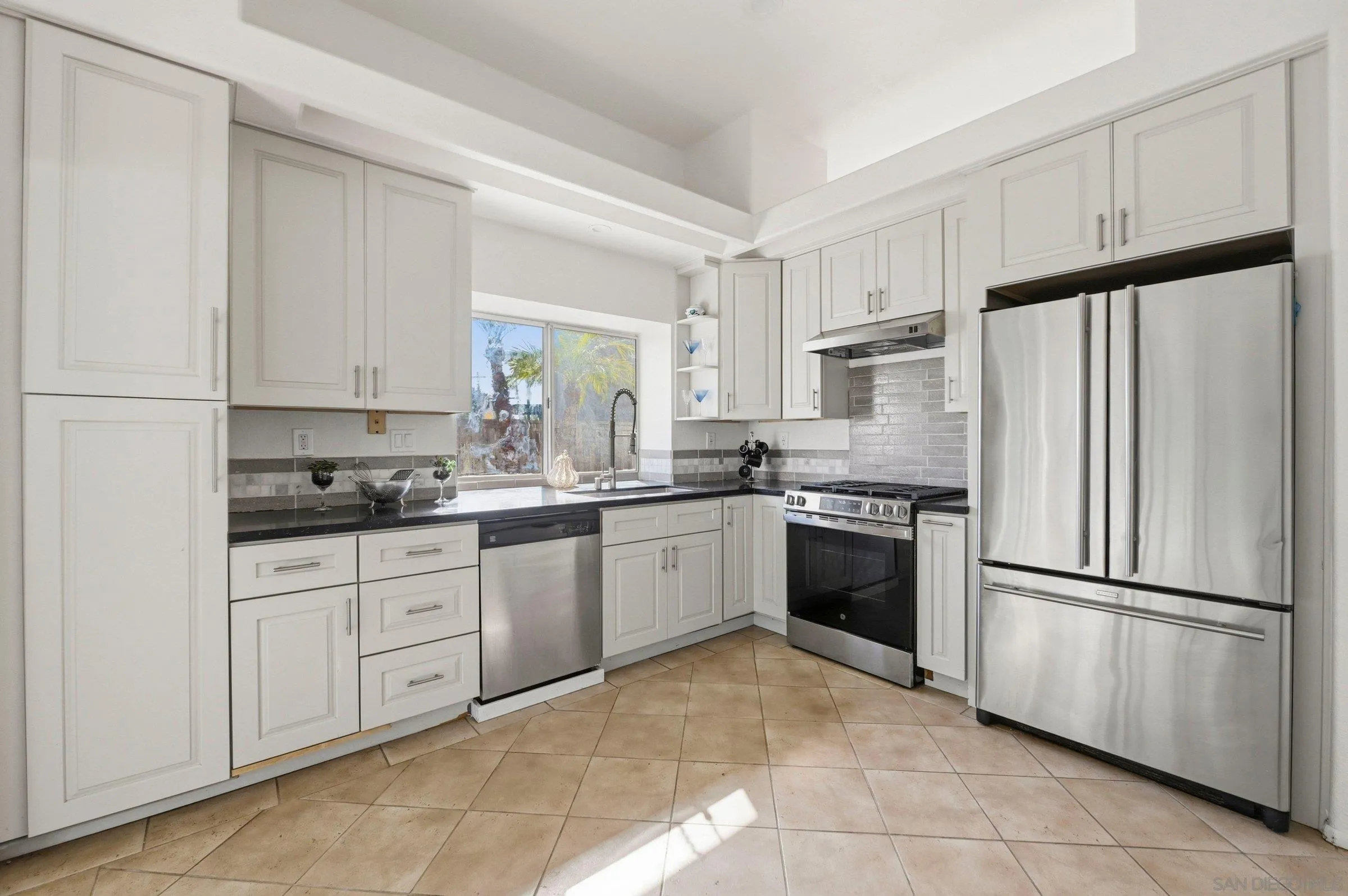 4290 Via Clemente Oceanside, CA 92057 - Photo 4 of 34 a kitchen with granite countertop a refrigerator sink and cabinets