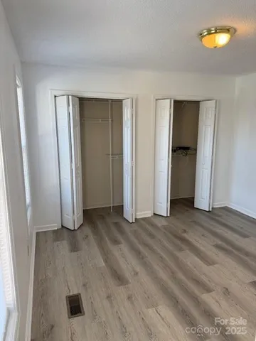 an empty room with windows and closet