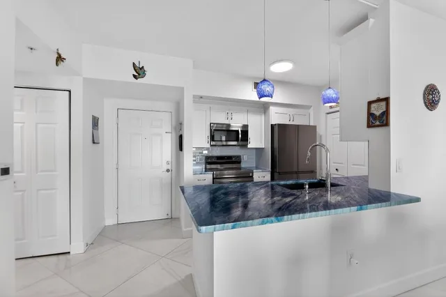 a kitchen with kitchen island granite countertop a stove refrigerator and microwave