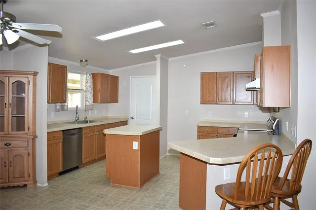a kitchen with a sink chairs and stove