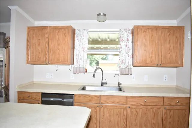 a kitchen with stainless steel appliances granite countertop a sink a stove and a refrigerator with wooden cabinets