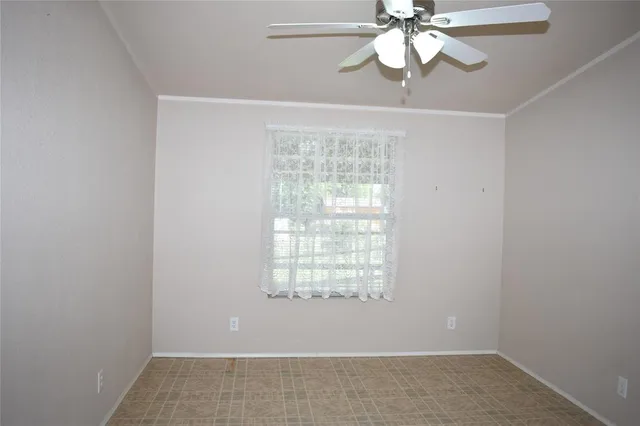 en empty room with window and wooden floor