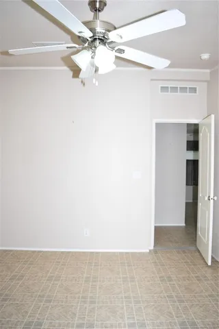 an empty room with a ceiling fan and a window